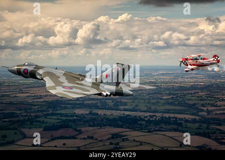 Die Avro Vulcan Bomber Formation fliegt mit einem Christen Eagle II oberhalb von Northamptonshire. Stockfoto