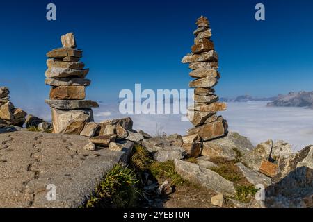 Steinpyramide in den Bergen auf dem Gipfel und untain Pass, der den Weg markiert Stockfoto