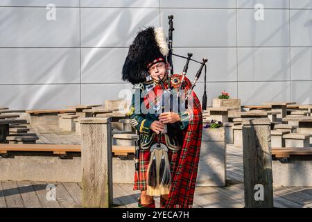 Halifax, Nova Scotia - 12. September 2024: Ein ortsansässiger Musiker, der Dudelsack spielt, macht Busse auf der Promenade am Ufer von Halifax. Stockfoto