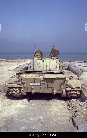 Erster Golfkrieg: 10. März 1991 die Rückansicht eines verlassenen irakischen chinesischen Panzers Typ 69 in seiner sandsackigen Verkleidung am Anjafa Beach in Kuwait City. Stockfoto