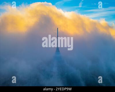 Das majestätische Gebäude steht inmitten eines dramatischen, wolkenreichen Sonnenuntergangs, mit leuchtenden Farbtönen, die den Himmel über Liberec beleuchten und eine fesselnde Atmosphäre schaffen. Stockfoto
