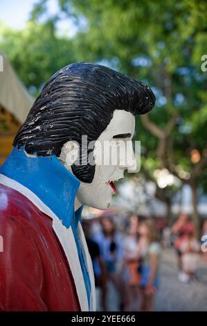 Verwitterte, lebensechte Statue von Elvis in einer belebten Straße der Algarve Stockfoto