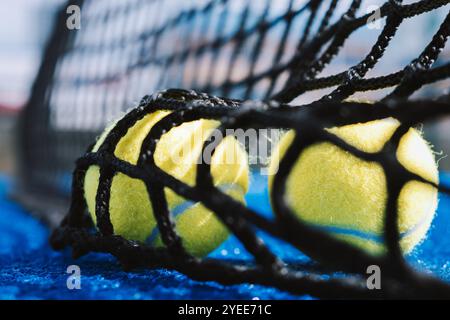 Zwei Bälle hinter dem Netz auf einem Paddeltennisplatz, Konzept des Racketsport-Hintergrunds Stockfoto