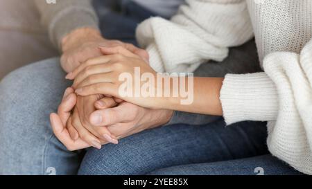 Nicht Erkennbares Paar Hält Die Hände Auf Der Couch Im Innenbereich, Zugeschnitten Stockfoto