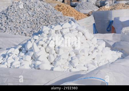 Weiße Marmorkiesel werden auf dem Baumarkt verkauft. Nahaufnahme des Materialstapels. Materialien für Dekoration und Konstruktion. Stockfoto