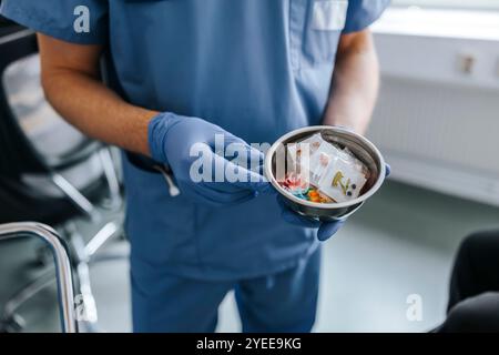 Hochwinkelansicht eines männlichen Arztes, der eine Schüssel mit Spielzeug mit guten Augen hält Stockfoto