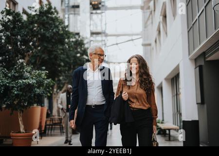 Glücklicher Geschäftsmann und Geschäftsfrau, die zusammen in der Lobby spazieren Stockfoto