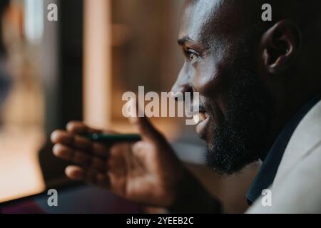 Glücklicher reifer Geschäftsmann, der während seiner Arbeit im Büro Gesten macht Stockfoto