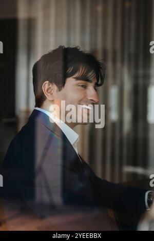 Seitenansicht eines glücklichen jungen Geschäftsmannes im Büro Stockfoto