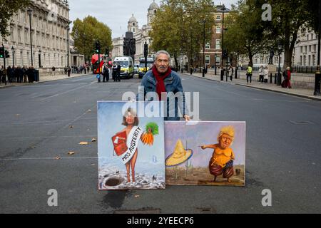London, Schiedam, Großbritannien. 30. Oktober 2024. Ein Demonstrant steht mit mehreren regierungsfeindlichen Gemälden. Am 30. Oktober 2024 wurde die Ankündigung des ersten nationalen Haushalts der britischen Labour-Regierung in London auf Proteste gestoßen. Um 11:00 Uhr versammelten sich britische Bürger in der Downing Street 10. Nachdem das Budget gegen 12 Uhr abgelesen worden war, zogen die Demonstranten in die Houses of Parliament im Palace of Westminster. (Kreditbild: © James Petermeier/ZUMA Press Wire) NUR REDAKTIONELLE VERWENDUNG! Nicht für kommerzielle ZWECKE! Stockfoto