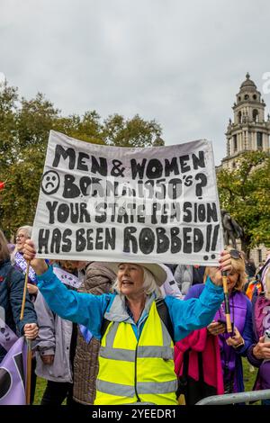 London, Schiedam, Großbritannien. 30. Oktober 2024. Ein Demonstrant hält ein Banner mit der Aufschrift „Männer und Frauen geboren in den 1950er Jahren? Ihre Staatsrente Wurde Ausgeraubt. Am 30. Oktober 2024 protestierten Mitglieder der britischen Interessenvertretungsgruppe WASPI (Women Against State Pension Injustice) vor den Houses of Parliament. Sie forderten eine Entschädigung für Frauen, die von den Änderungen der Rentengesetze in den Jahren 1995 und 2011 betroffen waren. (Kreditbild: © James Petermeier/ZUMA Press Wire) NUR REDAKTIONELLE VERWENDUNG! Nicht für kommerzielle ZWECKE! Stockfoto