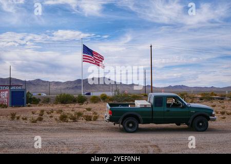 Pick-up-Truck parkt auf der Landstraße neben der US-Flagge an der Truckstop an der Route 93, Mojave County, Arizona. Stockfoto