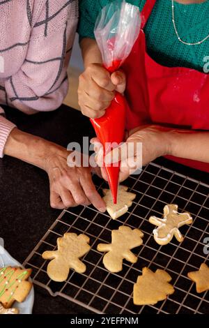 weihnachtskekse zusammen dekorieren, Seniorinnen zu Hause Stockfoto