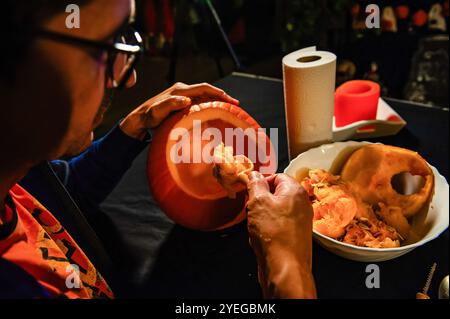 Nijmegen, Niederlande. 30. Oktober 2024. Ein Mann beginnt, einen Kürbis zu schnitzen. Als die Halloween-Nacht näher rückt, besuchten die Menschen eine Farm in der Nähe der Stadt Nijmegen, um Kürbisse zum Schnitzen zu kaufen. Nach Angaben der Landwirte waren aufgrund des kalten und nassen Wetters 30 Prozent weniger Kürbisse als üblich geerntet. Quelle: SOPA Images Limited/Alamy Live News Stockfoto