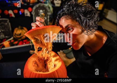 Nijmegen, Niederlande. 30. Oktober 2024. Eine Frau wird gesehen, wie sie einem Kürbis den Mumm rausnimmt. Als die Halloween-Nacht näher rückt, besuchten die Menschen eine Farm in der Nähe der Stadt Nijmegen, um Kürbisse zum Schnitzen zu kaufen. Nach Angaben der Landwirte waren aufgrund des kalten und nassen Wetters 30 Prozent weniger Kürbisse als üblich geerntet. Quelle: SOPA Images Limited/Alamy Live News Stockfoto