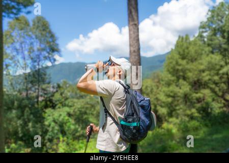 FIT junger männlicher Wanderer im Nature Forest Trekking mit fröhlichen und muskulösen Gesten mit einem Hund Stockfoto