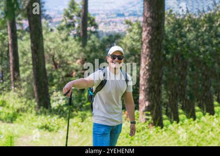 FIT junger männlicher Wanderer im Nature Forest Trekking mit fröhlichen und muskulösen Gesten mit einem Hund Stockfoto