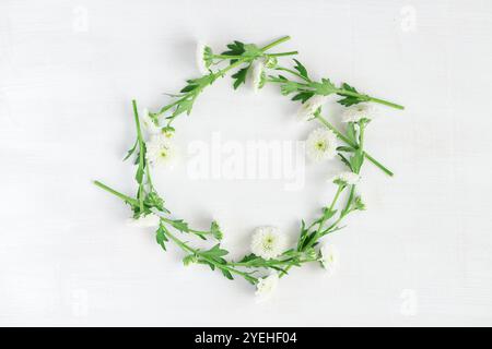 Schöner Kranz mit weißen Blumen auf weißem hölzernem Hintergrund Stockfoto