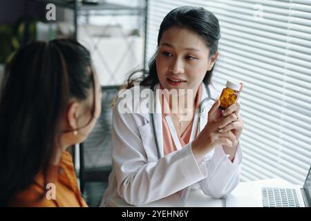 Asiatische Apothekerin Diskutiert Medikamentöse Vorteile Stockfoto