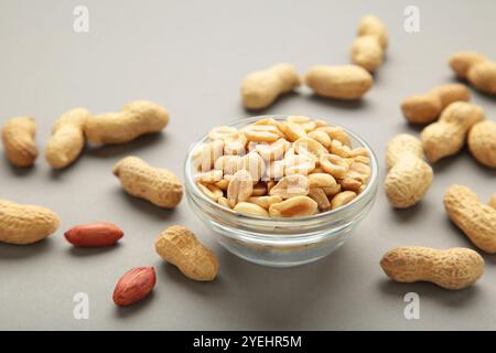 Geröstete Erdnüsse auf Schüssel auf grauem Hintergrund. Draufsicht Stockfoto