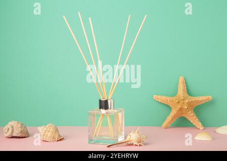 Reed-Diffusor und Muscheln auf mintfarbenem Hintergrund. Draufsicht Stockfoto