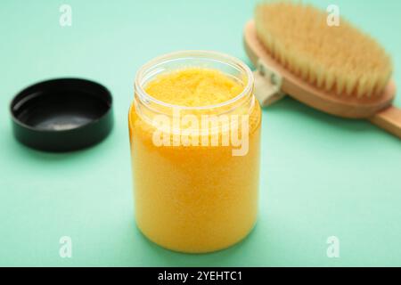 Handgefertigtes Sugar Pfirsichpeeling Mit Arganöl. Mit Massagebürste auf mintfarbenem Hintergrund schrubben. Draufsicht Stockfoto