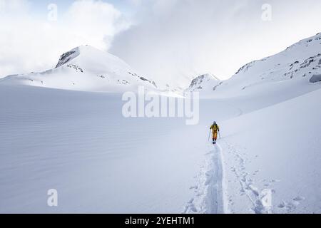 Einsamer Skitourer in verschneite Berglandschaft, Aufstieg zum Wildhorn, bewölkte Stimmung, Hochtour, Berner Alpen, Berner Oberland, Schweiz, Europa Stockfoto