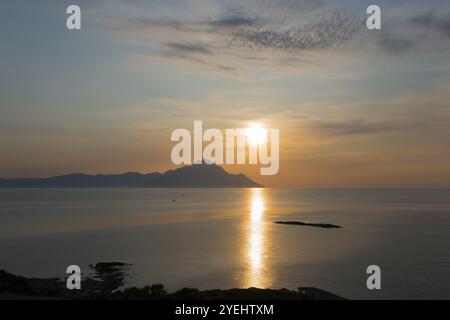 The sun rises, illuminating the sea and an island in the distance, view of Mount Athos, Orthodox monastic republic with autonomous status under Greek Stock Photo