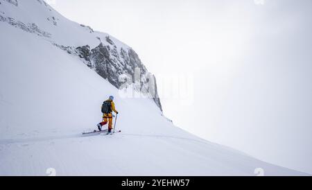 Einsamer Skitourer in verschneite Berglandschaft im Morgenlicht, Aufstieg zum Wildhorn, bewölkte Stimmung, Hochtour, Berner Alpen, Berner Oberland, Swit Stockfoto