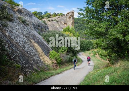 Radfahrer fahren vorbei an Rocher de Rocalinaud, Beaumes-de-Venise, Vaucluse in der Region Provence-Alpes-Côte d'Azur im Südosten Frankreichs Stockfoto