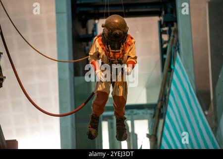 Ein antiker Tiefseetauchanzug, der in der Luft hängt, möglicherweise als Teil eines Museums. Stockfoto