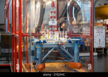 Ein detailliertes Modell einer Offshore-Bohrinsel, das in einer Museumsausstellung ausgestellt ist, umgeben von einem Glaskasten mit lebhaften Farben und komplizierten Strukturen. Stockfoto