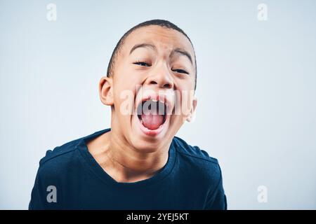 Schreien, schreien und Porträt eines Kindes im Studio mit Wut, Verärgerung und verrückter Reaktion auf weißem Hintergrund. Frustriert, Gesichtsausdruck und isoliert jung Stockfoto