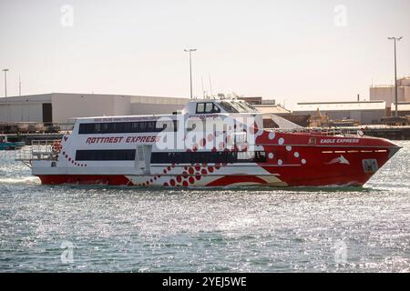 Eine rot-weiße Passagierfähre namens „Rottnest Express“ segelt auf ruhigen Gewässern. Stockfoto