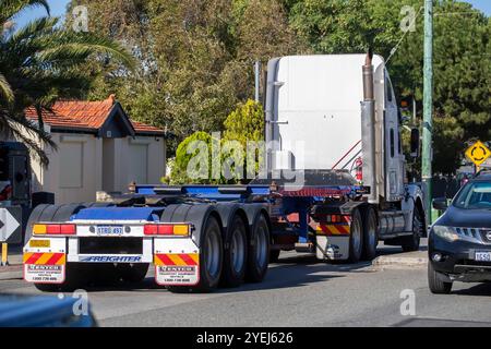 Rückansicht eines Freightliner coronado Sattelaufliegers mit leerem Anhänger, der durch eine Vorstadtstraße fährt. Stockfoto