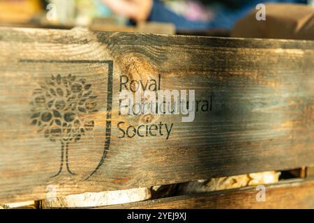 Hölzernes Schild im RHS Harlow Carr, Harrogate, North Yorkshire, Großbritannien mit dem Logo der Royal Horticultural Society Stockfoto