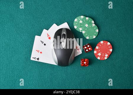 Online-Casino-Spielekonzept mit Computermaus, die Karten und Würfel spielen und Chips auf grüner Matte setzen. Draufsicht. Stockfoto