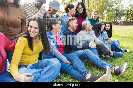 Gruppe von Menschen aus mehreren Generationen, die gemeinsam Spaß im Stadtpark haben - glückliche Freunde verschiedener Altersgruppen, die einen sonnigen Tag im Freien genießen Stockfoto