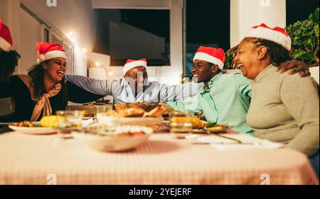 Glückliche afrikanische Familie, die Spaß beim gemeinsamen Essen während der Weihnachtszeit hat - Weihnachtskonzept - Hauptfokus auf Vatergesicht Stockfoto