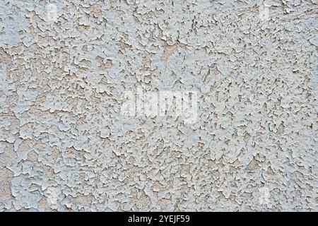 Strukturierte graue Oberfläche mit Rissen und Unebenheiten. Abblätternder Hintergrund der Farbwand. Stockfoto