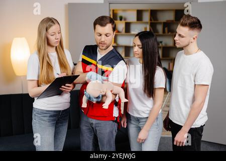 Gruppe von Personen, die während des Trainings im Innenbereich erste Hilfe mit dem Blindkind leisten lernen. Stockfoto