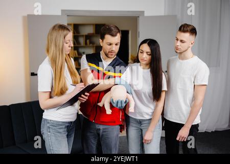 Gruppe von Personen, die während des Trainings im Innenbereich erste Hilfe mit dem Blindkind leisten lernen. Stockfoto