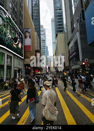 Fußgänger überqueren Queen's Road Central in Hongkong. Stockfoto