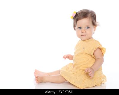 Wunderschönes blauäugiges Mädchen im Studio Foto mit gelbem Kleid auf weißem Hintergrund und Blick zur Kamera. Stockfoto