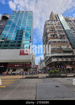 Ein altes Gebäude aus den 1960er Jahren neben einem modernen Gebäude an der Nathan Road in Kowloon, Hongkong. Stockfoto