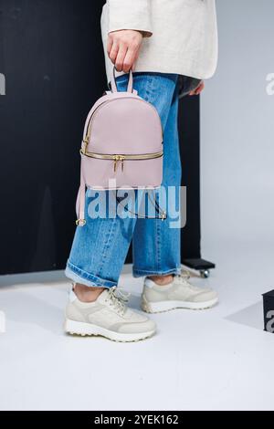 Rosafarbener Lederrucksack in den Händen einer Frau. Damenrucksack. Stockfoto