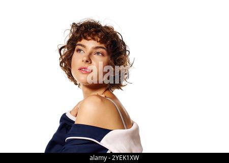 Die junge Frau zeigt ihre emotionale Tiefe mit einer nachdenklichen Pose vor einem hellen Hintergrund. Stockfoto