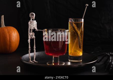 Halloween rote und orange alkoholische Cocktails auf schwarzem Hintergrund. Getränk für eine festliche Party. Stockfoto