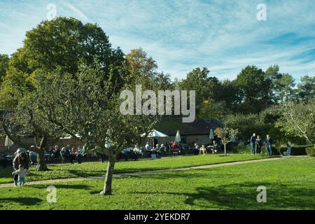 Besucher genießen eine Pause im Café auf dem Gelände von Bateman's, dem ehemaligen Zuhause von Rudyard Kipling an einem sonnigen Herbsttag Stockfoto