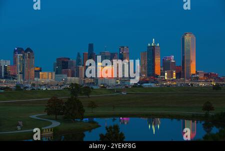 Malerischer Blick auf die Skyline von Downtown Dallas vom Trammell Crow Park mit abendlicher Sonne, die von Gebäuden reflektiert wird Stockfoto